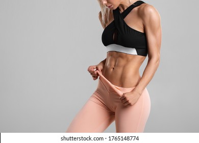 Fitness woman showing abs and flat belly, isolated. Athletic girl shaped abdominal