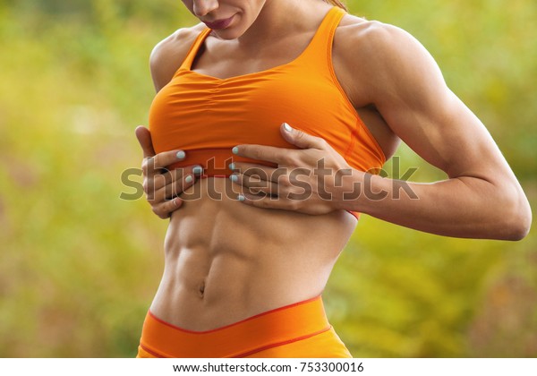 腹筋と平腹を見せるフィットネス ウーマン 屋外で運動をする女の子 腹部の形をした 細い腰 の写真素材 今すぐ編集
