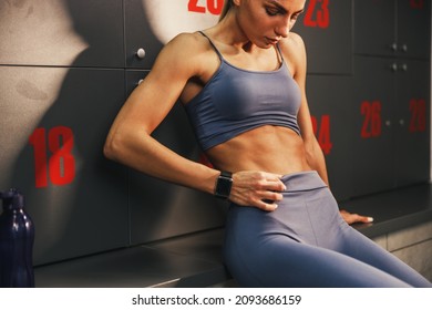 Fitness Woman Showing Her Six Pack While Resting In Dressing Room After Hard Training At The Gym.