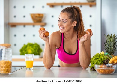 A Fitness Woman Is Showing Off Chicken Eggs. She Stands With Them In Her Hands And A Kitchen In The Background. Smiling Woman Holding Egg. Fitness Woman Prepare Healthy Breakfast.