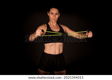 Similar – Side profile view portrait of one young athletic woman at crossfit training, exercising with trx suspension fitness straps over dark background, looking away