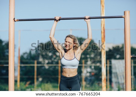 Fitness woman tightening on a turnstile