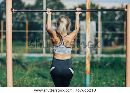 Fitness woman tightening on a turnstile