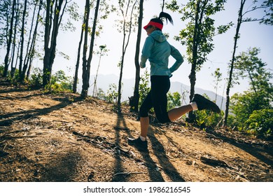 Fitness woman trail runner running on sunrise tropical forest mountain peak - Powered by Shutterstock