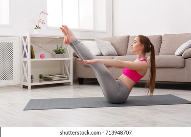 Fitness, Woman Training Yoga In Boat Pose At Home. Young Slim Girl Makes Exercise.