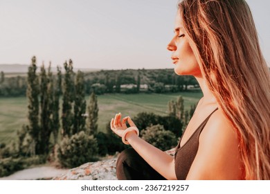 Fitness woman. Well looking middle aged woman with long hair, fitness instructor in leggings and tops doing stretching and pilates on the rock near forest. Female fitness yoga routine concept. - Shutterstock ID 2367219257