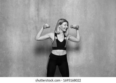 Fitness Woman Working Out With Dumbbells. Body Of A Young Fit Woman Lifting Dumbell. Black And White Filter