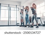 Fitness, women and group with kettlebell for weight training, wellness and body workout. Team, cardio and personal trainer challenge with active routine for health exercise at class in gym center