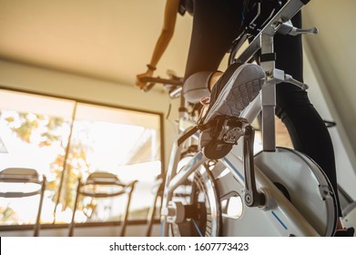 fitness ,workout, gym exercise ,lifestyle  and healthy concept. Rear view of woman workout with bike. Women exercise working out in the gym for healthy lifestyle on bike at sunset. - Shutterstock ID 1607773423