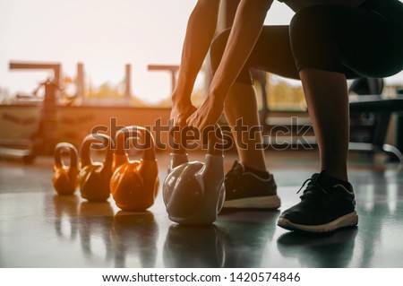 fitness ,workout, gym exercise ,lifestyle  and healthy concept.Woman in exercise gear standing in a row holding dumbbells during an exercise class at the gym.Fitness training with kettlebell in sport 