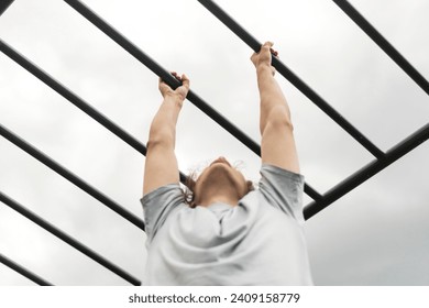 fitness workout on monkey bars outdoors, arm muscles training, climbing on ladder - Powered by Shutterstock