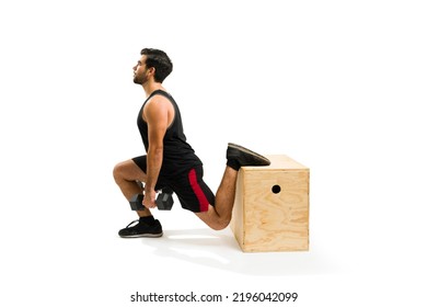 Fitness young man practicing leg lunges using dumbbell weights with a jump box for his cross training workout - Powered by Shutterstock