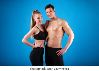 Fitness young man and woman isolated on blue background.