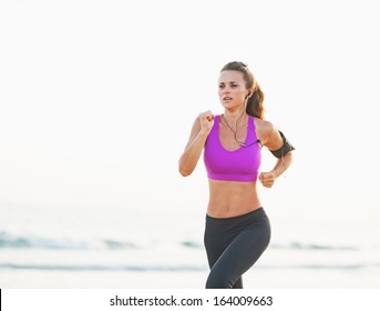 Fitness Young Woman Running On Beach