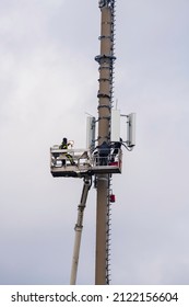 Fitters with a riser to a mobile phone mast during maintenance work