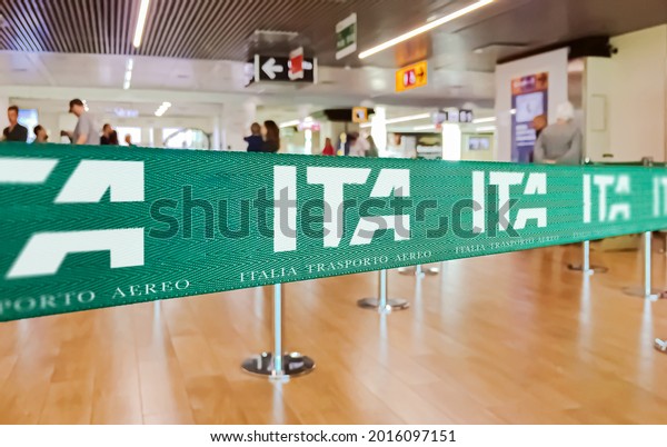 Fiumicino, Italy, July 2021: green ribbon barrier\
with the ITA airline logo inside the Leonardo da Vinci airport in\
Rome, Italy. ITA is the new Italian flag carrier starting from 15\
October 2021