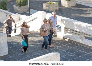 Five adults walking across elevated walkway