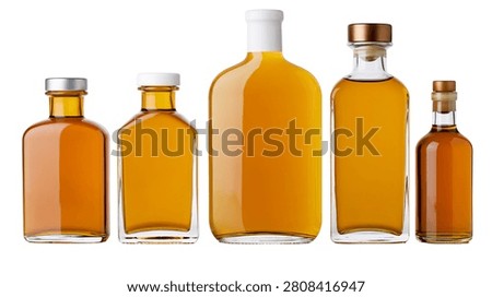 Five assorted glass bottles filled with golden amber liquid and various caps
