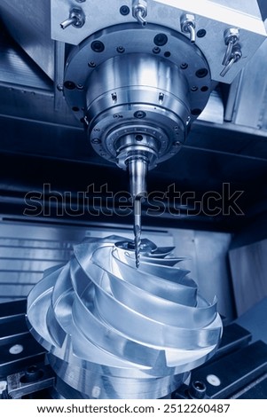 Five axis CNC machining center cutting engine turbine, blue toning. Concept modern technology for industry.