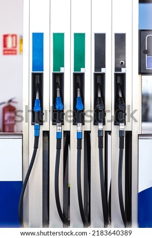 Five black and blue fuel hoses at a gas station. Concept of gasoline, diesel, liquefied gas, LPG, gallon, super, crisis, expensive and transportation.