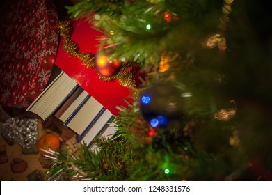 Five Books In A Gift Box Under A Christmas Tree Decorated With Balls And Garlands