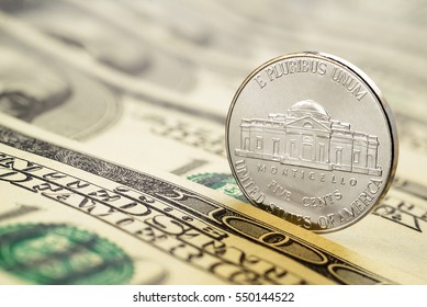 Five cents nickel US coin on hundred dollar bills. Macro shot