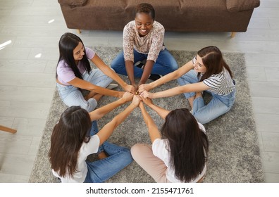 Five Close Friends Enjoying Friendship And Spending Time Together. Diverse Group Of Happy Positive Confident Young Women Holding Hands Sitting In Circle On Floor At Home, Overhead Top View From Above