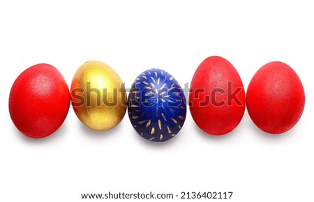 Five colorful easter eggs in a row, one gold, one blue with gold pattern, and three red, isolated on white background