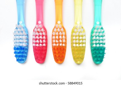 Five colorful toothbrushes on white background