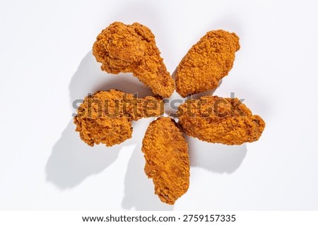 Five crispy deep-fried chicken wings arranged in a circle on whi