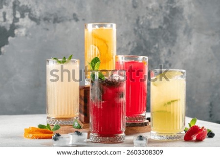 Five different glasses of lemonade on the table, drinks with berries and citrus fruits