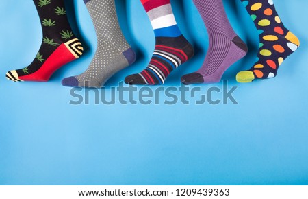 five different men's socks in a row on a pastel blue background