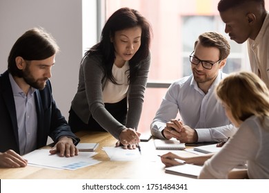 Five diverse business workgroup designers team with asian woman leader discuss paperwork financial report statistical data, forecasting working on common project. Brainstorm, briefing activity concept - Shutterstock ID 1751484341