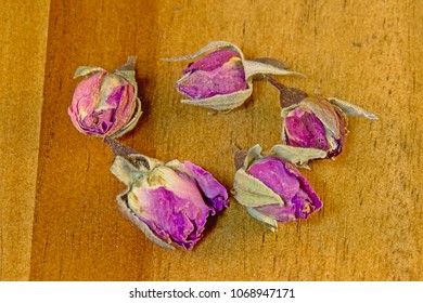 Five Dried Pink Rose Buds On Wood Background, Overhead View - Rosaceae