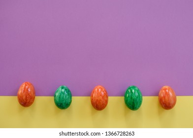 Five easter eggs on a yellow and violet background.