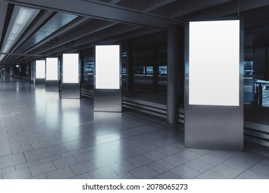 Five empty vertical posters mock-ups glowing with a LED neon light in an airport terminal; a group of blank banners templates in a corridor of a shopping mall; mockups of 5 indoor billboards in a hall