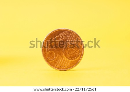 Five  euro cent close up on a yellow background