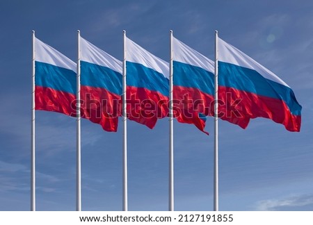 Five flags of Russia. Dramatic cloudy sky in the background. Banners flutter in the wind.