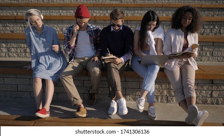 Five friends sitting together, each is busy with another activit - Shutterstock ID 1741306136