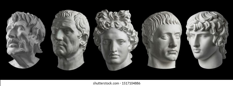 Five gypsum copy of ancient statue heads isolated on a black background. Plaster sculpture mans faces.