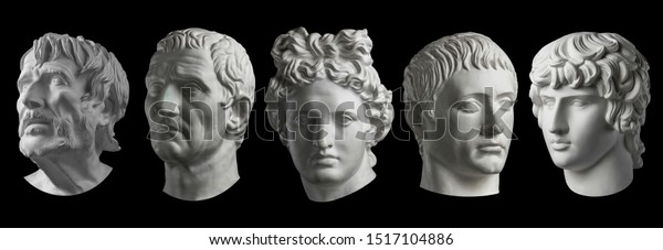 Five gypsum copy of ancient\
statue heads isolated on a black background. Plaster sculpture mans\
faces.