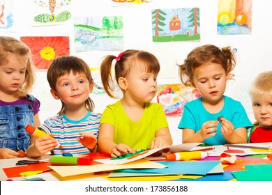 Five happy little 3-4 years old kids sitting by the table on creative paint an glue lesson - Shutterstock ID 173856188