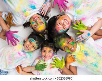 Five Indian Kids Making Circle On Holi, Asian Small Kids Or Siblings Or Friends With Heads Together In Round, With Faces Coloured With Gulal