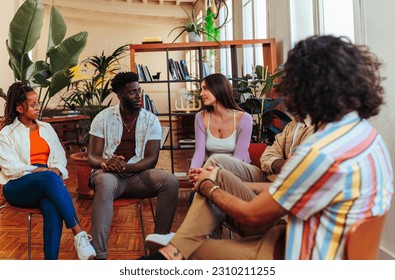 Five interracial young people having a conversation on the group recovery therapy session - Powered by Shutterstock