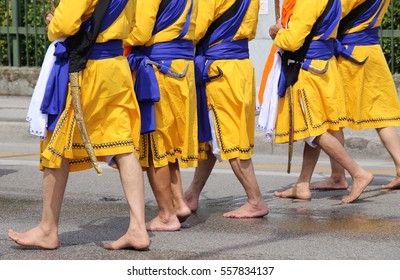 Five men with long dresses walking barefoot through the streets of the city during the religious event