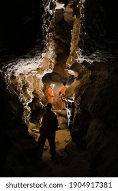 Five men, strong physique, explore the cave. Men dressed in special clothes to pass through the cave and stopped, looking at the map.