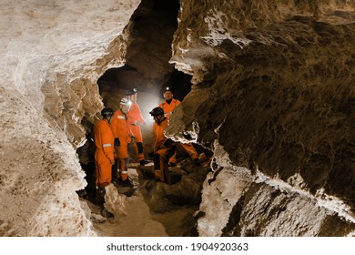 Five Men, Strong Physique, Explore The Cave. Men Dressed In Special Clothes To Pass Through The Cave And Stopped, Looking At The Map.