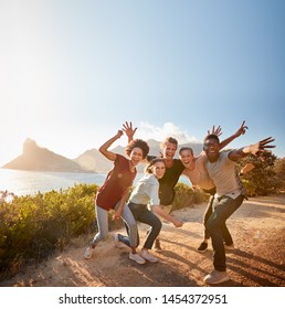 Five Millennial Friends On A Road Trip Have Fun Posing For Photos On A Coastal Path, Full Length