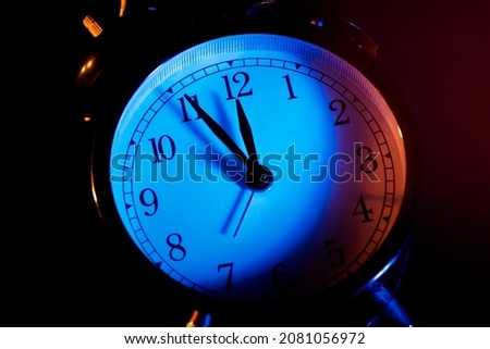 Five minutes to midnight. Changing the clocks, time adjustment, daylight savings or new year concept on retro analog clock, close up