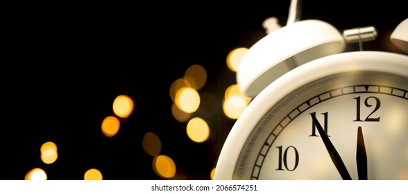 Five minutes to midnight. Midnight countdown to new year. Abstract firework sparks on dark sky background, copy space photo - Powered by Shutterstock